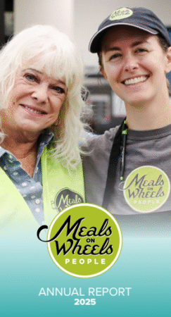 Two smiling women wearing "Meals on Wheels People" shirts and accessories. One wears a light green vest; the other a cap. Text reads "Annual Report 2025."