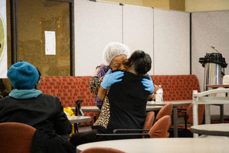 Diners share a hug at Meals on Wheels People's MLK Center during congregate lunch