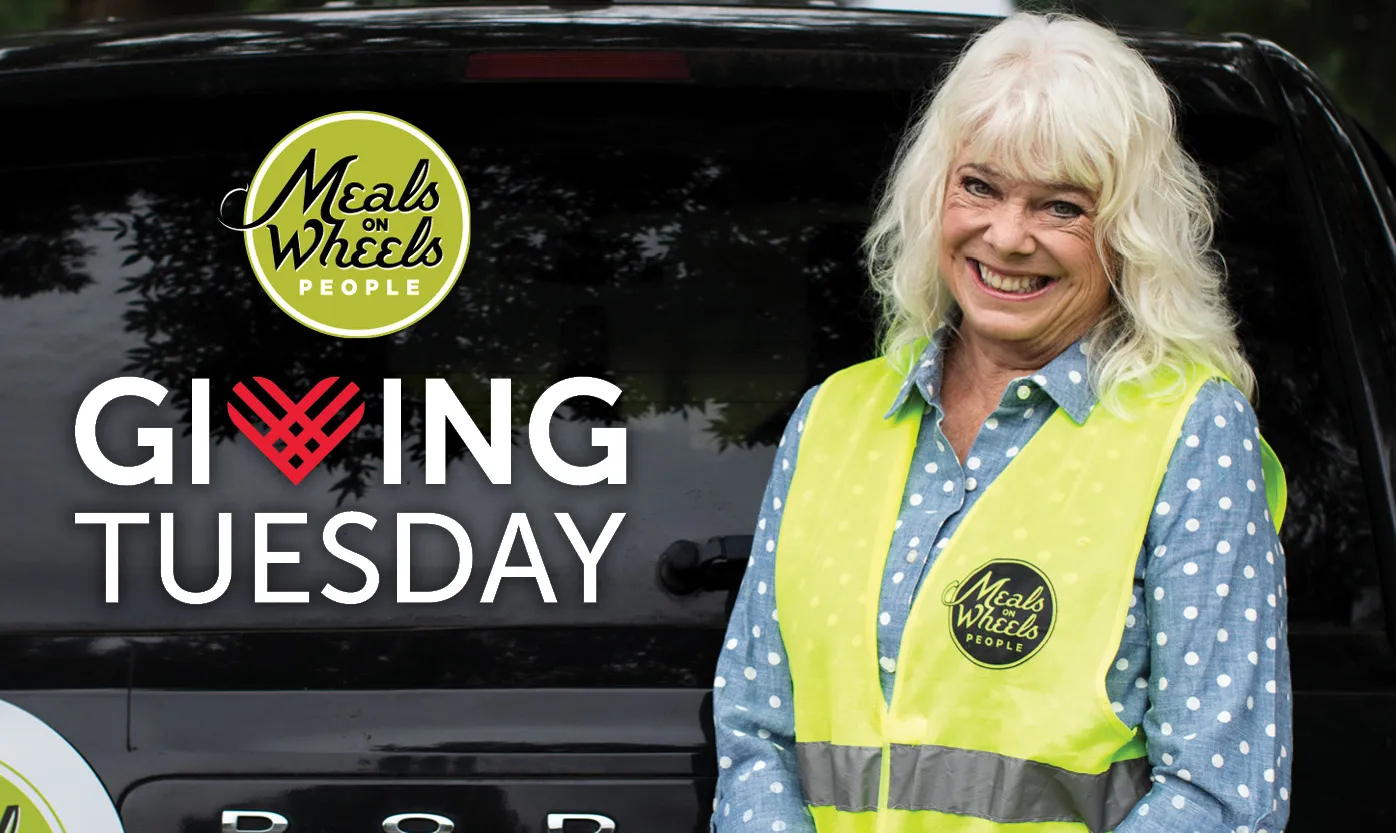 Volunteer in a Meals on Wheels People safety vest smiles
