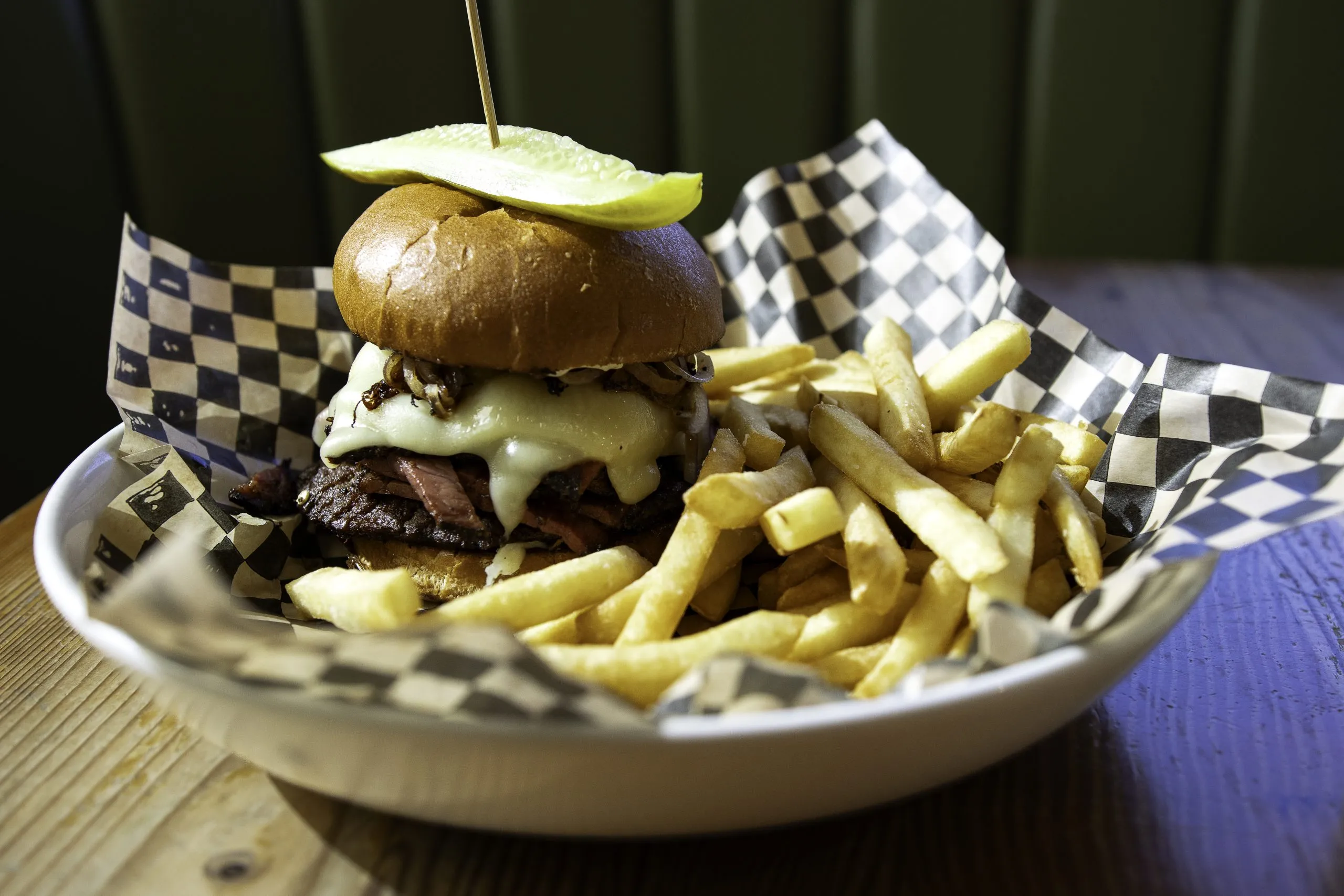 A quarter-pound beef patty topped with 4 oz. of housemade pastrami, grilled red onion, Swiss cheese, and garlic aioli on a brioche bun